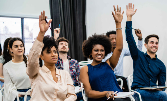 a group of workshop attendees raising their hands to ask questions